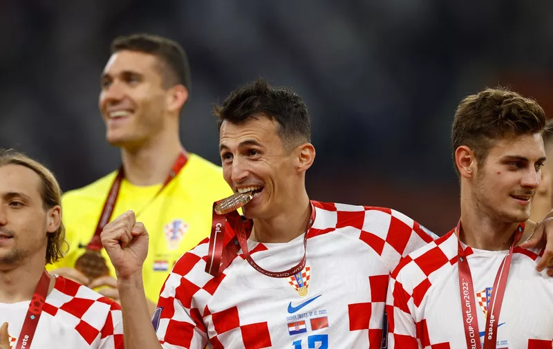Soccer Football - FIFA World Cup Qatar 2022 - Third-Place Playoff - Croatia v Morocco - Khalifa International Stadium, Doha, Qatar - December 17, 2022 Croatia's Ante Budimir and teammates celebrate with their medals on stage as they finish in third place REUTERS/Peter Cziborra