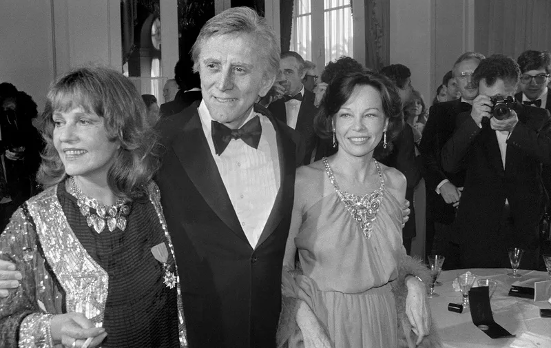 (FILES) In this file photo taken on May 9, 1980 US actor Kirk Douglas is accompanied by French actresses Jeanne Moreau (L), and Leslie Caron, during the Cannes International Film Festival. - US silver screen legend Kirk Douglas, the son of Jewish Russian immigrants who rose through the ranks to become one of Hollywood's biggest-ever stars, has died at 103, his family said on February 5, 2020. (Photo by RALPH GATTI / AFP)
