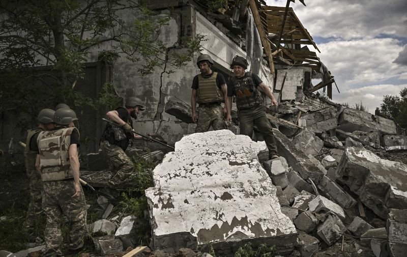 Ukrainian soldiers inspect a destroyed warehouse reportedly targeted by Russian troops on outskirts of Lysychansk, in the eastern Ukrainian region of Donbas on June 17, 2022, as the Russian-Ukraine war enters its 114th day. (Photo by ARIS MESSINIS / AFP)