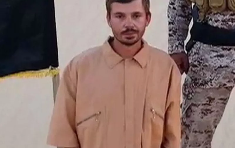 An image grab taken from a video made available by Egyptian affiliate of the Islamic State (IS) group's media outlet Welayat Sayna on August 5, 2015, shows Croatian national Tomislav Salopek kneeling on the sand next to an IS flag, in front of a man, while holding a piece of paper. IS's Egyptian affiliate threatened to execute within 48 hours the Croatian man kidnapped in Cairo on July 22, 2015, if Muslim women jailed in Egypt are not freed. In the video taken at an undisclosed location, Salopek reads from a sheet of paper that he will be executed within 48 hours if the Egyptian government fails to meet the jihadists' demand. AFP PHOTO / HO / WELAYAT SAYNA
=== RESTRICTED TO EDITORIAL USE - MANDATORY CREDIT "AFP PHOTO / HO / WELAYAT SAYNA" - NO MARKETING NO ADVERTISING CAMPAIGNS - DISTRIBUTED AS A SERVICE TO CLIENTS FROM ALTERNATIVE SOURCES, AFP IS NOT RESPONSIBLE FOR ANY DIGITAL ALTERATIONS TO THE PICTURE'S EDITORIAL CONTENT, DATE AND LOCATION WHICH CANNOT BE INDEPENDENTLY VERIFIED ===