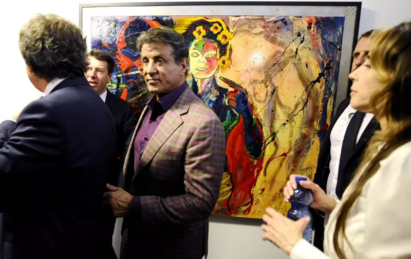 US actor Sylvester Stallone (C) and Mayor of Nice Christian Estrosi (2nd R) walk past an artwork at a retrospective of Stallone's paintings entitled "Real Love" Paintings 1975-2015 at the Museum of Contemporary Art in Nice, southeastern France, on May 16, 2015.  AFP PHOTO / FRANCK PENNANT
= RESTRICTED TO EDITORIAL USE, MANDATORY MENTION OF THE ARTIST UPON PUBLICATION, TO ILLUSTRATE THE EVENT AS SPECIFIED IN THE CAPTION =