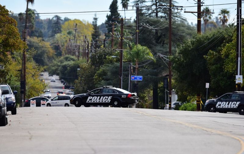 Police block a street on which FBI agents are investigating a townhome and a car in Redlands, California December 3, 2015 linked to the December 2 shooting rampage in San Bernardino, California. At least 14 people were killed in a gun attack on a holiday party in San Bernardino, in the country's worst mass shooting since the massacre of 26 people at Sandy Hook elementary school in Connecticut in 2012. A heavily armed man and woman killed 14 people and injured at least 17 at a social services center before the suspects died during a shootout with police.  AFP PHOTO /ROBYN BECK (Photo by ROBYN BECK / AFP)