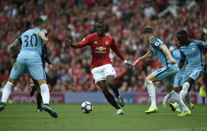 Manchester United's French midfielder Paul Pogba (2nd L) runs with the ball during the English Premier League football match between Manchester United and Manchester City at Old Trafford in Manchester, north west England, on September 10, 2016. / AFP PHOTO / Oli SCARFF / RESTRICTED TO EDITORIAL USE. No use with unauthorized audio, video, data, fixture lists, club/league logos or 'live' services. Online in-match use limited to 75 images, no video emulation. No use in betting, games or single club/league/player publications.  /