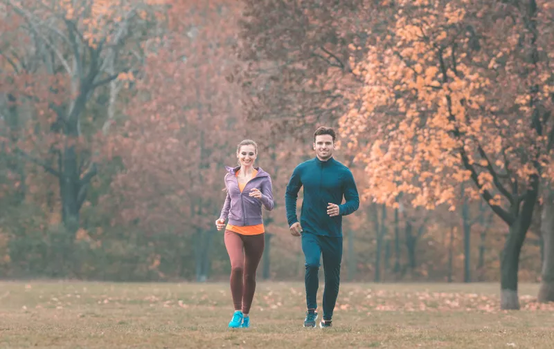 Couple in wonderful fall landscape running for better fitness towards the camera,Image: 558762764, License: Royalty-free, Restrictions: , Model Release: yes