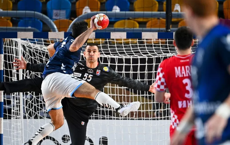 Argentina's wing Ignacio Pizarro (L) tries to score past Croatia's goalkeeper Marin Sego  during the 2021 World Men's Handball Championship match between Group II teams Argentina and Croatia at the Cairo Stadium Sports Hall in the Egyptian capital on January 23, 2021. (Photo by Anne-Christine POUJOULAT / POOL / AFP)