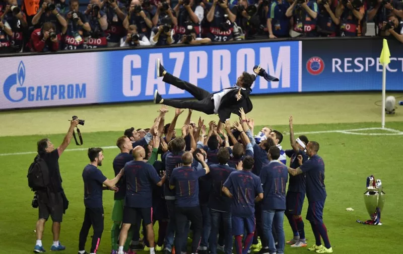 Barcelona's players throw Barcelona's coach Luis Enrique in the air after the UEFA Champions League Final football match between Juventus and FC Barcelona at the Olympic Stadium in Berlin on June 6, 2015.  FC Barcelona won the match 1-3.   AFP PHOTO / ODD ANDERSEN