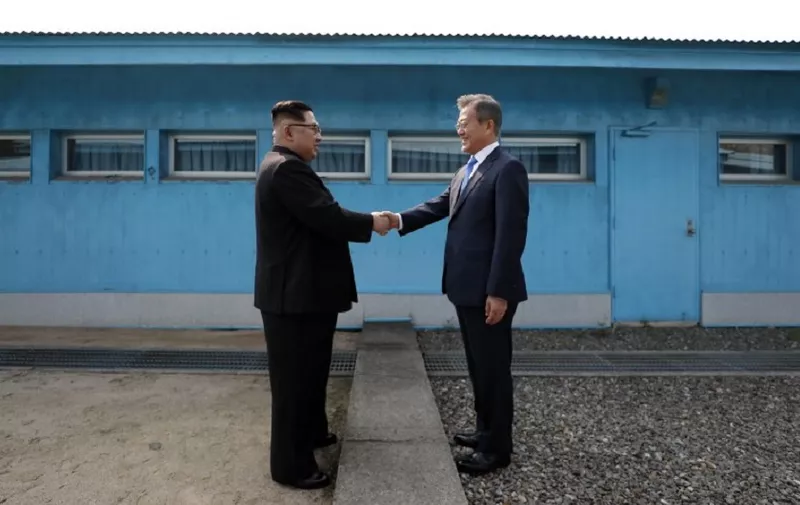North Korea's leader Kim Jong Un (L) shakes hands with South Korea's President Moon Jae-in (R) at the Military Demarcation Line that divides their countries ahead of their summit at the truce village of Panmunjom on April 27, 2018.
North Korean leader Kim Jong Un and the South's President Moon Jae-in sat down to a historic summit on April 27 after shaking hands over the Military Demarcation Line that divides their countries in a gesture laden with symbolism. / AFP PHOTO / Korea Summit Press Pool / Korea Summit Press Pool