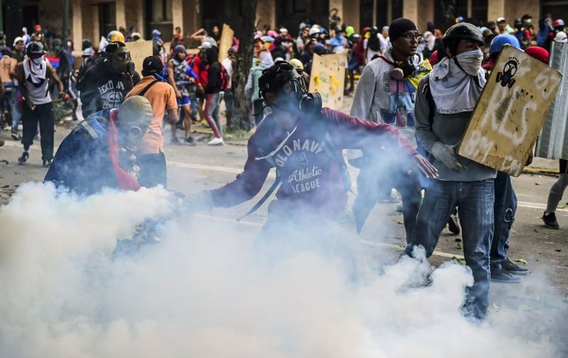 Opposition demonstrators clash with riot police during an anti-government protest in Caracas, on July 20, 2017. 
A 24-hour nationwide strike got underway in Venezuela Thursday, in a bid by the opposition to increase pressure on beleaguered leftist President Nicolas Maduro following four months of deadly street demonstrations. / AFP PHOTO / RONALDO SCHEMIDT