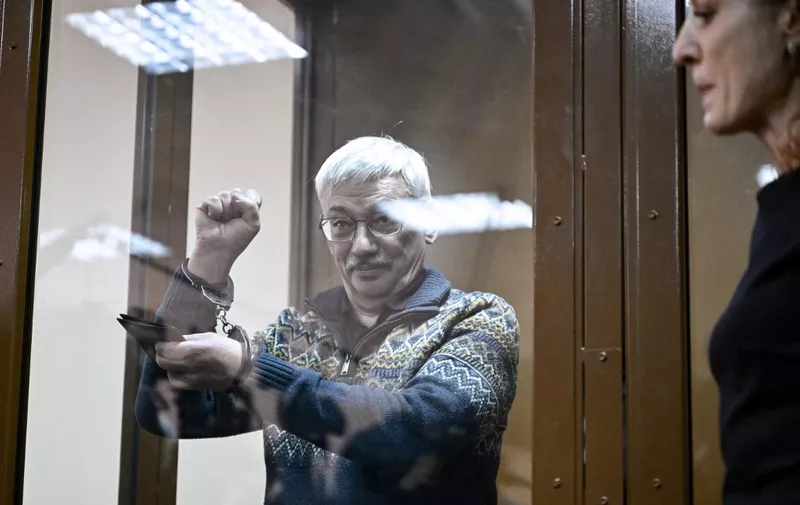 Oleg Orlov, the 70-year-old human rights campaigner and co-chair of the Nobel Prize winning Memorial group, is seen handcuffed after being sentenced to two and a half years in jail on charges of repeatedly "discrediting" the Russian army, in Moscow on February 27, 2024. (Photo by Alexander NEMENOV / AFP)
