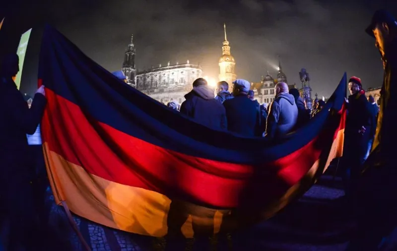 TOPSHOTS
Supporters of the PEGIDA movement, "Patriotische Europaeer gegen die Islamisierung des Abendlandes," which translates to "Patriotic Europeans Against the Islamisation of the Occident" gather at a protest rally on October 19, 2015 in Dresden, eastern Germany. AFP PHOTO / DPA /  RALF HIRSCHBERGER     +++ GERMANY OUT +++