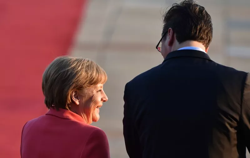 Serbian Prime Minister Aleksandar Vucic (R) welcomes German Chancellor Angela Merkel prior to their meeting in Belgrade, Serbia, on July 8, 2015. Angela Merkel is on a two-day visit to the Balkan States of Albania, Serbia and Bosnia, three countries whose ambitions to join the European Union have been complicated by the Greek crisis and their mutual rivalries.  AFP PHOTO / ANDREJ ISAKOVIC