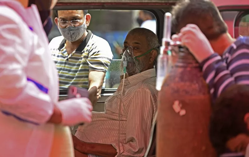 A patient breathes with the help of oxygen provided by a Gurdwara, a place of worship for Sikhs, inside a van parked under a tent along the roadside amid Covid-19 coronavirus pandemic in Ghaziabad on April 26, 2021. (Photo by Sajjad HUSSAIN / AFP)