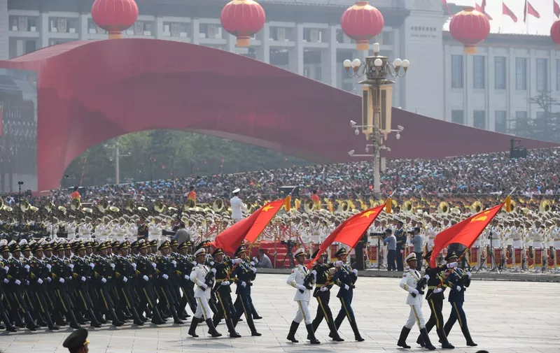 Chinese soldiers march with the national flag (C), flanked by the flags of the Communist Party of China (R) and the People's Liberation Army (L) during a military parade at Tiananmen Square in Beijing on October 1, 2019, to mark the 70th anniversary of the founding of the People's Republic of China. (Photo by GREG BAKER / AFP)