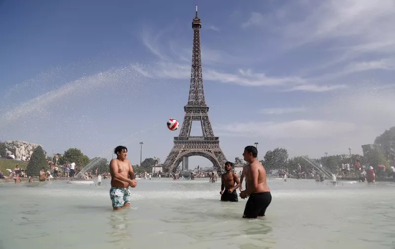 People play as they bathe in the Trocadero Fountain in front of the Eiffel Tower in Paris during a heatwave on June 28, 2019. - The temperature in France on June 28 surpassed 45 degrees Celsius (113 degrees Fahrenheit) for the first time as Europe wilted in a major heatwave, state weather forecaster Meteo-France said. (Photo by Zakaria ABDELKAFI / AFP)