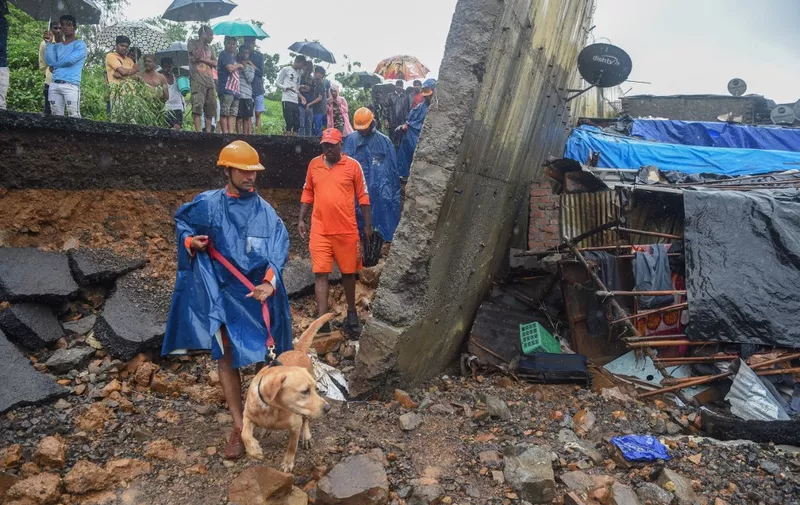 Rescue workers use dogs to search for survivors at the site of a wall collapse in Mumbai on July 2, 2019. - At least 15 people were killed in India's financial capital of Mumbai early on July 2 when a wall collapsed during torrential monsoon downpours. The tragedy came as the teeming coastal settlement of 20 million residents was lashed by heavy rains for a second consecutive day, bringing the city to a virtual standstill. (Photo by PUNIT PARANJPE / AFP)