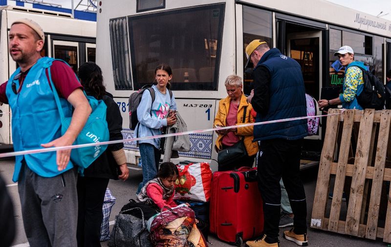 People evacuated from Mariupol's Azovstal plant arrive on buses at a registration and processing area for internally displaced people in Zaporizhzhia on May 3, 2022. - The UN says 101 civilians have been "successfully evacuated" from Ukraine's besieged and battered port city of Mariupol in a joint effort with the Red Cross. (Photo by Dimitar DILKOFF / AFP)