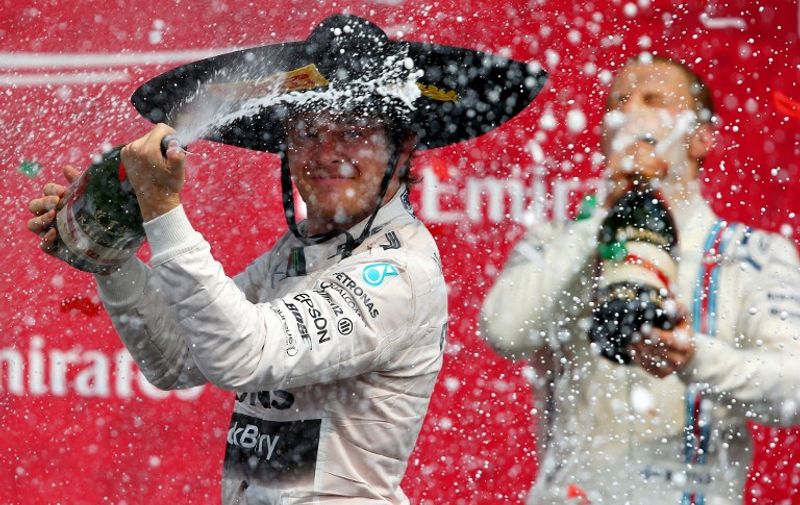 MEXICO CITY, MEXICO - NOVEMBER 01: Nico Rosberg of Germany and Mercedes GP celebrates on the podium next to Valtteri Bottas of Finland and Williams after winning the Formula One Grand Prix of Mexico at Autodromo Hermanos Rodriguez on November 1, 2015 in Mexico City, Mexico.   Mark Thompson/Getty Images/AFP