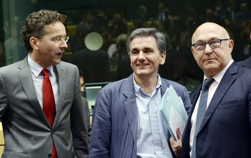 (From ) Dutch Finance Minister and president of the Eurogroup Jeroen Dijsselbloem, newly appointed Greek Finance Minister Euclid Tsakalotos, and French Economy, Finance and Trade Minister Michel Sapin are pictured during a Eurogroup meeting ahead of a Eurozone Summit meeting at the EU headquarters in Brussels on July 7, 2015.       AFP PHOTO / THIERRY CHARLIER