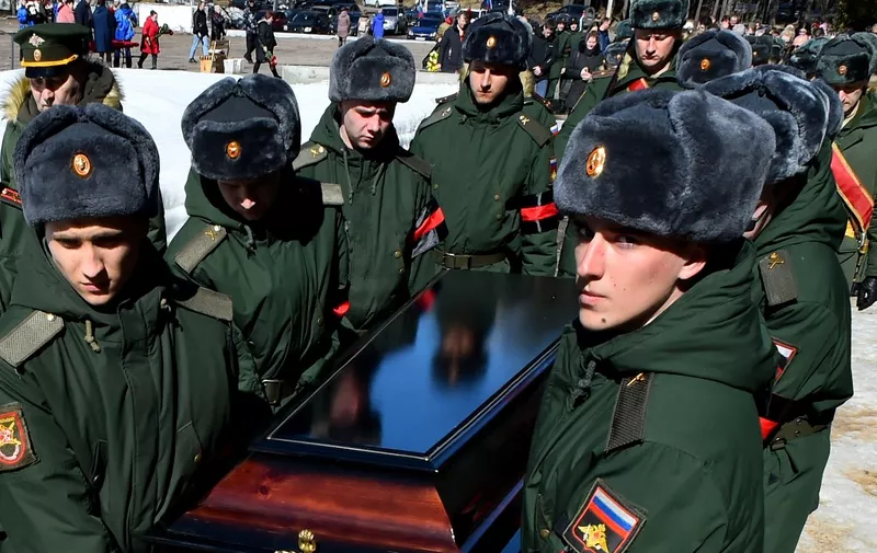 Soldiers carry a coffin of 20-year-old Russian serviceman Nikita Avrov, during his funeral at a church in Luga some 150kms south of Saint Petersburg on April 11, 2022, after his death on March 27, during the ongoing Russian invasion of Ukraine. (Photo by AFP)