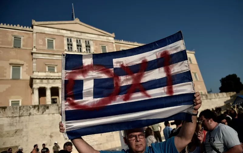 Protesters participate in a demonstration calling for a "No" vote in the forthcoming referendum on bailout conditions set by the country's creditors,  in front of the Greek parliament in Athens on June 29, 2015. Greece shut its banks and the stock market and imposed capital controls after creditors at the weekend refused to extend the country's bailout past the June 30 deadline, prompting anxious citizens to empty ATM's. AFP PHOTO / ARIS MESSINIS