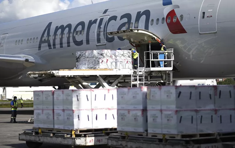 Airport employees unload a batch of three million doses of the Moderna vaccine against COVID-19 donated by the US from an American airlines airplane upon its landing at the Aurora International Airport in Guatemala City, on July 20, 2021. (Photo by Johan ORDONEZ / AFP)