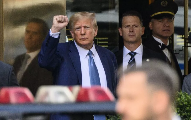 Former US President  Donald Trump pumps his fist as he departs Trump Tower in New York on April 13, 2023. - Trump is to be deposed Thursday in a $250 million lawsuit brought by New York Attorney General Letitia James, alleging that Trump and his children fraudulently overvalued the former presidents assets by billions of dollars. (Photo by ANGELA WEISS / AFP)