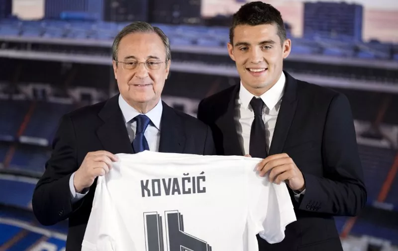 Real Madrid's new player Croatian Mateo Kovacic (R) and Real Madrid's president Florentino Perez hold Kovacic's new jersey during his official presentation at the Santiago Bernabeu stadium in Madrid on August 19, 2015.  AFP PHOTO / DANI POZO