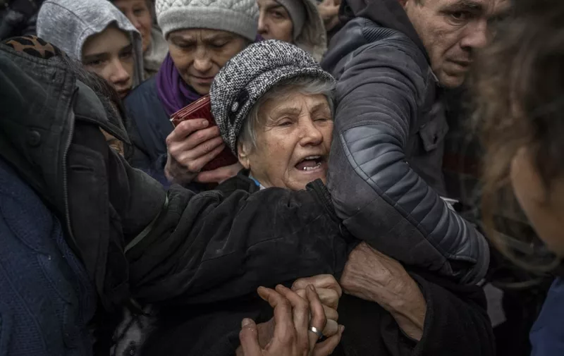 An elderly woman reacts as she waits for aid supply distribution in the centre of Kherson on November 18, 2022, amid the Russian invasion of Ukraine. (Photo by BULENT KILIC / AFP)
