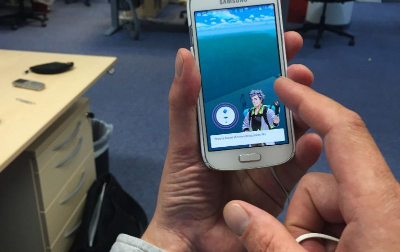 A man sets up his user avatar on the Pokemon Go mobile game after he downloaded it on to his smart phone in an office in Berlin on July 13, 2016.
The Pokemon Go mobile gaming craze reached European fans with players in Germany the first to get their hands on the augmented reality sensation. / AFP PHOTO / David GANNON
