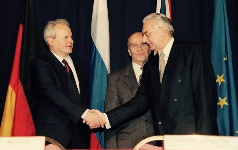Alija Izetbegovic, President of the Republic of Bosnia-Herzegovina (C) looks on as Franjo Tudman R), President of the Republic of Croatia, and Slobodan Milosevic (L), President of the Federal Yugoslavia (Serbia and Montenegro) shake hands after initializing a peace accord 21 November 1995 between their countries. Negotiations hosted by the US known as the Proximity Peace Talks at Wright-Patterson Air Force base, near Dayton, Ohion, began 01 November 1995.  / AFP PHOTO / JOHN RUTHROFF