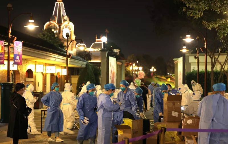This photo taken on October 31, 2021 shows medical personnel preparing to test visitors for the Covid-19 coronavirus at Disneyland in Shanghai after a single coronavirus case was detected at the park on the weekend. (Photo by AFP) / China OUT