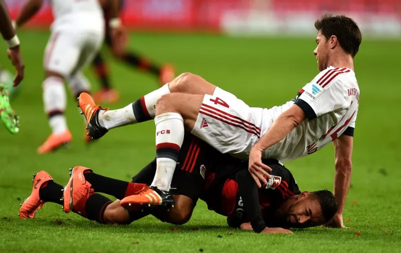 Bayern Munich's Spanish midfielder Xabi Alonso and Leverkusen's midfielder Karim Bellarabi vie for the ball during the German first division Bundesliga football match of Bayer 04 Leverkusen v Bayern Munich in Leverkusen, western Germany, on February 6, 2016.  / AFP / PATRIK STOLLARZ / RESTRICTIONS: DURING MATCH TIME: DFL RULES TO LIMIT THE ONLINE USAGE TO 15 PICTURES PER MATCH AND FORBID IMAGE SEQUENCES TO SIMULATE VIDEO. == RESTRICTED TO EDITORIAL USE == FOR FURTHER QUERIES PLEASE CONTACT DFL DIRECTLY AT + 49 69 650050