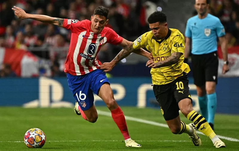 Atletico Madrid's Argentine defender #16 Nahuel Molina (L) fights for the ball with Dortmund's English midfielder #10 Jadon Sancho during the UEFA Champions League quarter final first leg football match between Club Atletico de Madrid and Borussia Dortmund at the Metropolitano stadium in Madrid on April 10, 2024. (Photo by JAVIER SORIANO / AFP)
