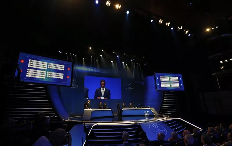 Former French football player Eric Abidal (screen) takes part in the UEFA Champions League Group stage draw ceremony, on August 27, 2015 in Monaco. AFP PHOTO / VALERY HACHE