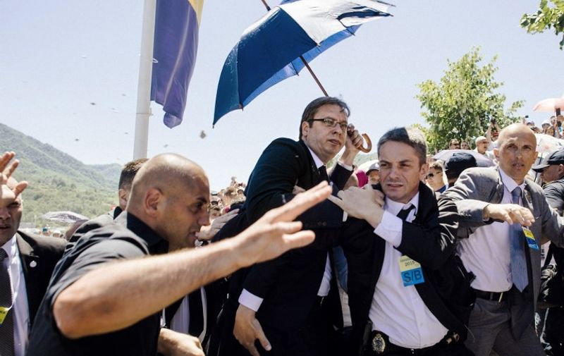TOPSHOTS
Bodyguards try to protect Serbian Prime Minister Aleksandar Vucic (C) from stones hurled at him by an angry crowd at the Potocari Memorial Center, near the eastern Bosnian town of Srebrenica on July 11, 2015. Tens of thousands of people gathered in Srebrenica on July 11 to commemorate the 20th anniversary of the massacre of thousands of Muslims in the worst mass killing in Europe since World War II. Serbian Prime Minister Aleksandar Vucic was forced to leave the Srebrenica memorial when the crowd started to chant 'Allahu Akbar' (God is Great) and to throw stones. AFP PHOTO / DIMITAR DILKOFF