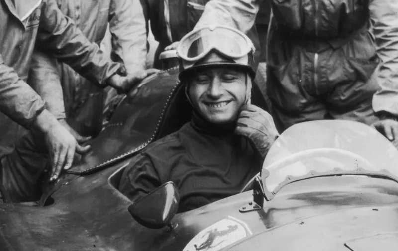 5th August 1956:  Mechanics gather round Argentinian racing driver Juan Manuel Fangio (1911 - 1995) in his Lancia Ferrari D50 after he won the German Grand Prix at the Nurburgring.  (Photo by Keystone/Getty Images)