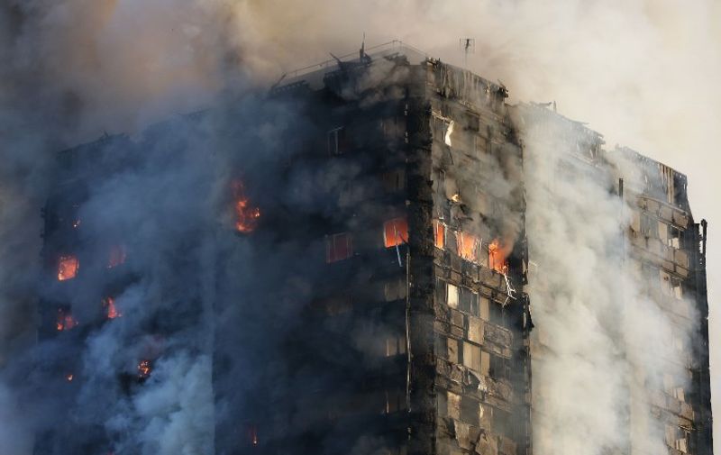 Smoke billows from Grenfell Tower as firefighters attempt to control a huge blaze on June 14, 2017 in west London.
The massive fire ripped through the 27-storey apartment block in west London in the early hours of Wednesday, trapping residents inside as 200 firefighters battled the blaze. Police and fire services attempted to evacuate the concrete block and said "a number of people are being treated for a range of injuries", including at least two for smoke inhalation.   / AFP PHOTO / Daniel LEAL-OLIVAS