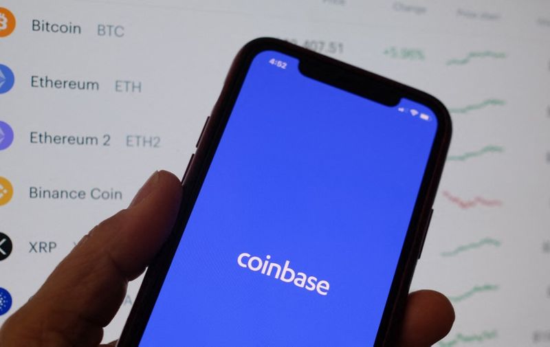 This illustration photo shows the Coinbase logo on a smartphone in Los Angeles on April 13, 2021. - The arrival April 13, 2021, of cryptocurrency exchange Coinbase on Nasdaq is one of the most anticipated events of the year on Wall Street, where enthusiasm for record-breaking bitcoin is in full swing, despite questions about the sustainability of the market. (Photo by Chris DELMAS / AFP)