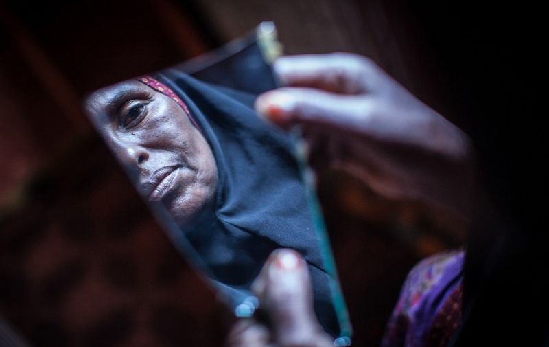 TO GO WITH AFP STORY BY HELEN VESPERINI
Amran Mahamood, who has made a living for 15 years by circumcising young girls, looks into a piece of a mirror on February 19, 2014 in Hargeysa. The centuries old tradition of female circumcision, also known as female genital mutilation (FGM), is on the decline in northern Somalia, though it continues to have some of the highest rates of women who have undergone the practice in the world. AFP PHOTO/ Nichole Sobecki / AFP / Nichole Sobecki