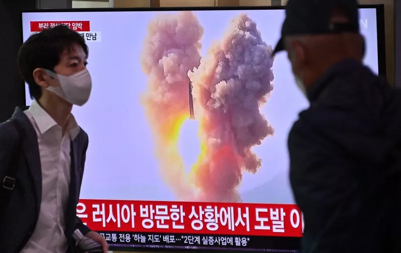 A man walks past a television screen showing a news broadcast with file footage of a North Korean missile test, at a railway station in Seoul on September 13, 2023. North Korea has fired two short-range ballistic missiles, the South Korean military said on September 13, with leader Kim Jong Un in Russia ahead of a summit with President Vladimir Putin. (Photo by Jung Yeon-je / AFP)