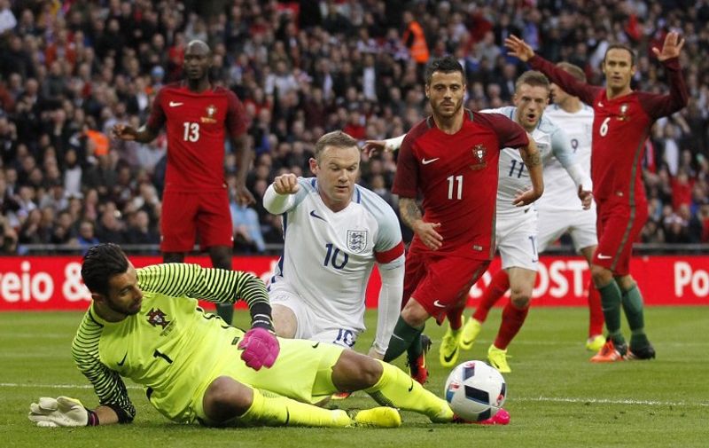 Portugal's goalkeeper Rui Patricio (L) saves the ball by England's striker Wayne Rooney during the friendly football match between England and Portugal at Wembley stadium in London on June 2, 2016.
 / AFP PHOTO / Ian Kington