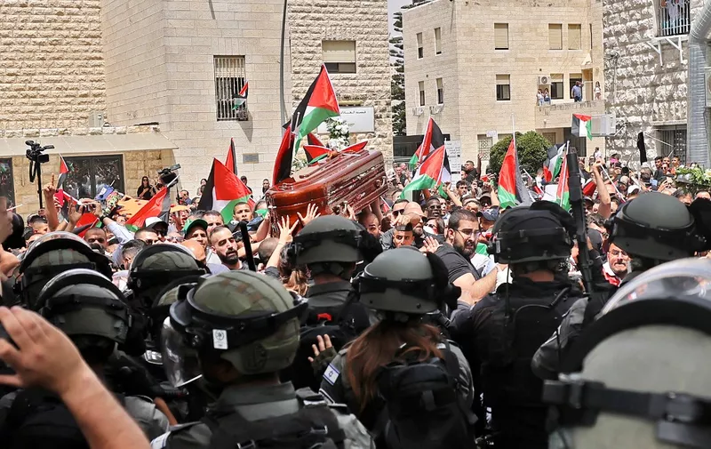 Violence erupts between Israeli security forces and Palestinian mourners carrying the coffin of slain  Al-Jazeera journalist Shireen Abu Akleh out of a hospital, before being transported to a church and then her resting place, in Jerusalem, on May 13, 2022. - Abu Akleh, who was shot dead on May 11, 2022 while covering a raid in the Israeli-occupied West Bank, was among Arab media's most prominent figures and widely hailed for her bravery and professionalism. (Photo by AHMAD GHARABLI / AFP)