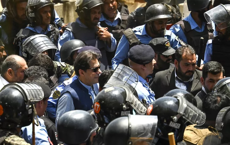 Policemen escort Pakistan's former Prime Minister Imran Khan (C) as he arrives at the high court in Islamabad on May 12, 2023. Khan appeared at court for a bail hearing on May 12, after the Supreme Court ruled unlawful his arrest this week that triggered deadly clashes across the country. (Photo by Aamir QURESHI / AFP)