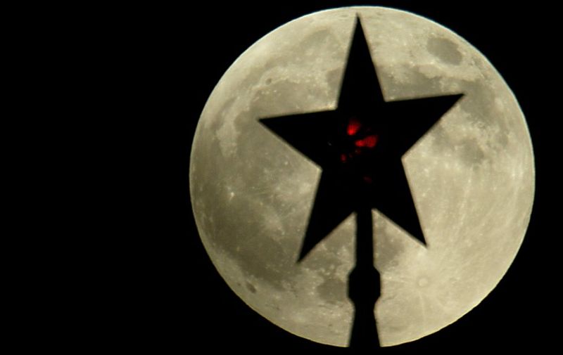 One of the Ruby stars of the Kremlin towers in Moscow is silhouetted on the full moon before the start of the lunar eclipse, 04 May 2004. AFP PHOTO / MLADEN ANTONOV