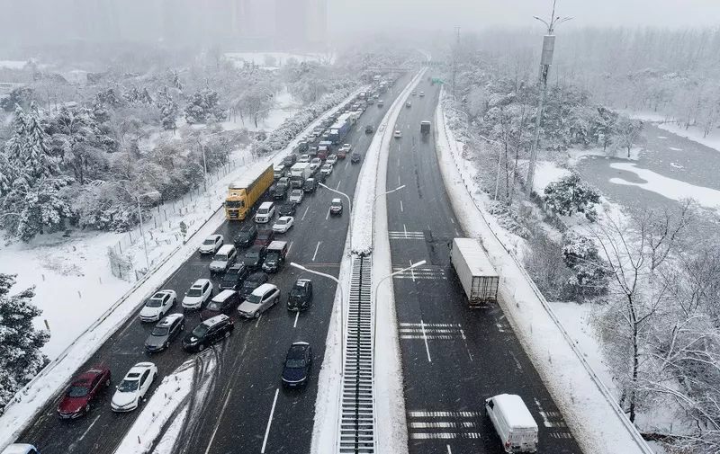 Vehicles make their way amid heavy traffic conditions during snowfall in Wuhan, in central China's Hubei province on February 6, 2024. (Photo by AFP) / China OUT