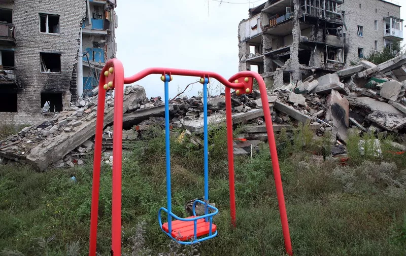 IZIUM, UKRAINE - SEPTEMBER 15, 2022 - A swing is pictured in front of an apartment building destroyed as a result of Russian shelling in Izium which was liberated from Russian invaders, Kharkiv Region, northeastern Ukraine.NO USE RUSSIA. NO USE BELARUS. (Photo by Vyacheslav Madiyevskyy / NurPhoto / NurPhoto via AFP)