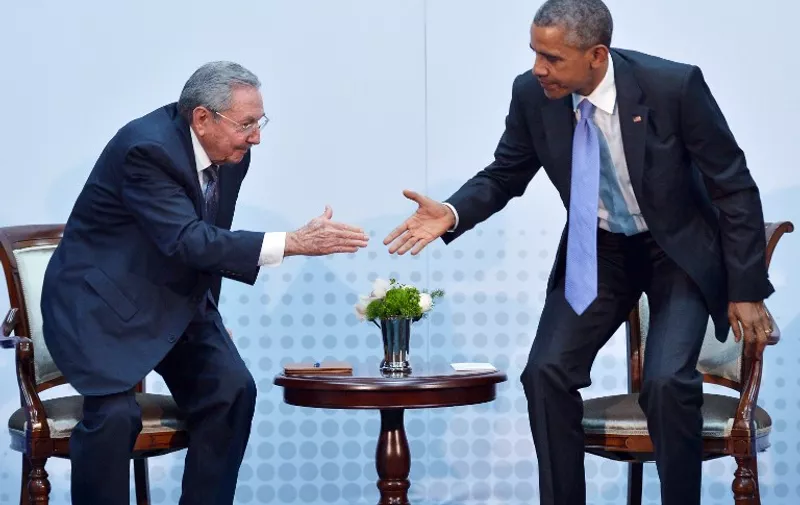 US President Barack Obama (R) and Cuba's President Raul Castro reach out to shake hands during a meeting on the sidelines of the Summit of the Americas at the ATLAPA Convention Center on April 11, 2015 in Panama City. AFP PHOTO/MANDEL NGAN
