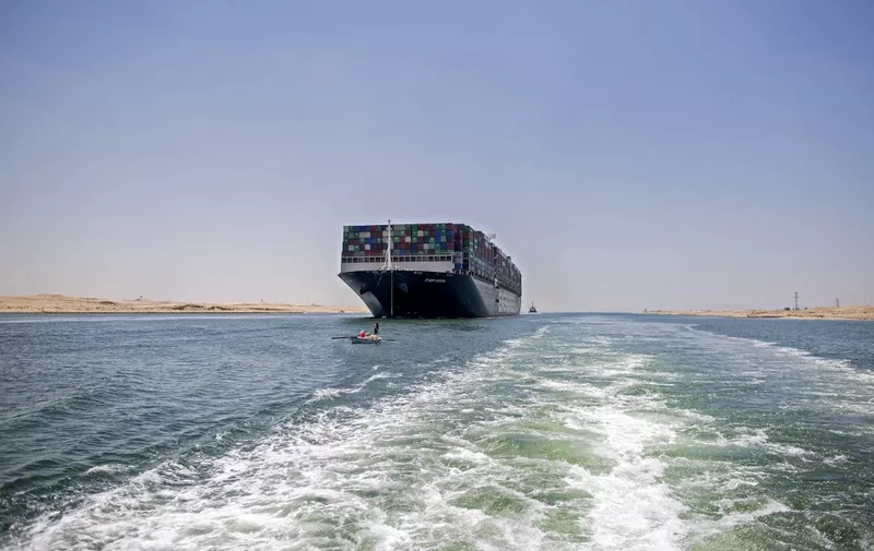 This picture on July 7, 2021 shows a view of the Panama-flagged MV 'Ever Given' container ship sailing along Egypt's Suez Canal near the canal's central city of Ismailia. Megaship the MV Ever Given, which had blocked the Suez Canal for six days in March, weighed anchor on July 7 after Egyptian authorities and the Japanese owner agreed a compensation deal. The 200,000-tonne container vessel was stuck in the waterway during a sandstorm on March 23, causing major disruption to world shipping and the loss of millions in revenue for Egypt. (Photo by Mahmoud KHALED / AFP)