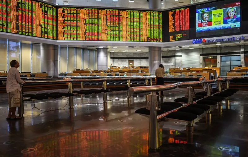 Traders monitor electronic boards showing stock movements during the final day of the US presidential election at a private stock exchange in Kuala Lumpur on November 9, 2016. 
Share markets collapsed Wednesday and the dollar tumbled against the yen and the euro as Donald Trump looked on course to win the race for the White House, in a stunning upset with major implications for the world economy. / AFP PHOTO / MOHD RASFAN