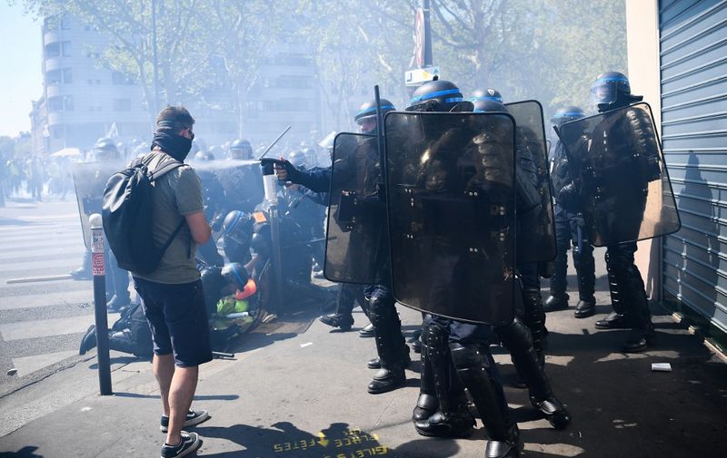 Anti-riot police detain protesters during clashes in Paris on April 20, 2019, as thousands of "Yellow Vest" (Gilets Jaunes) demonstrators took to the streets a 23rd week of anti-government marches. (Photo by Anne-Christine POUJOULAT / AFP)